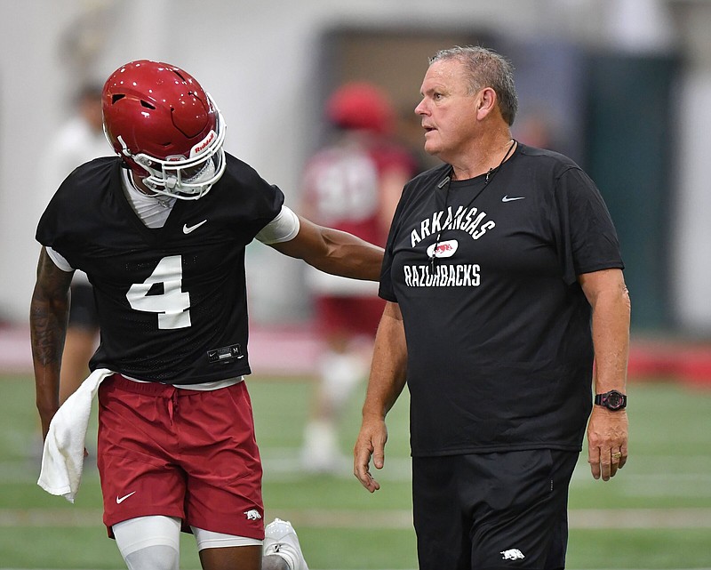 Arkansas sophomore Malik Hornsby greets Razorbacks Coach Sam Pittman on Friday in Fayetteville during the Hogs’ opening preseason practice. Pittman has said he plans to utilize Hornsby as a receiver in addition to his role as the Razorbacks’ backup quarterback. More photos available at arkansasonline.com/86uapractice/.
(NWA Democrat-Gazette/Andy Shupe)