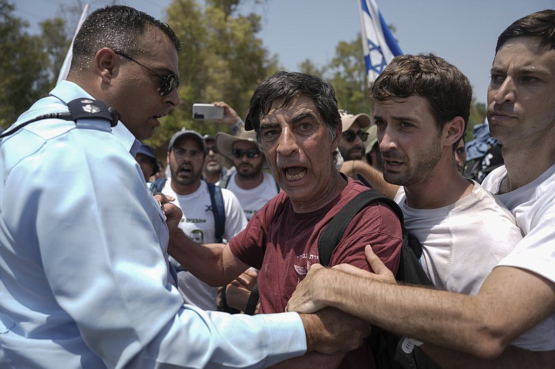 An Israeli police officer tries to block Simha Goldin (center), father of Israeli soldier Hadar Goldin, killed during the 2014 conflict in the Gaza Strip, from marching towards the Gaza border near Kibbutz Yad Mordechai, southern Israel on Friday. More photos at arkansasonline.com/86gaza/.
(AP/Ariel Schalit)
