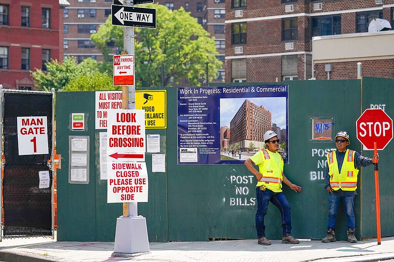 Construction workers help direct traffic outside a residential and commercial building under construction at the Essex Crossing development on the Lower East Side of Manhattan, Thursday, Aug. 4, 2022. (AP/Mary Altaffer)