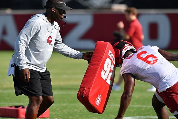 Arkansas assistant coach Jimmy Smith holds a blocking shield Friday, Aug. 5, 2022, while working with running back Rashod Dubinion (6) during practice at the university practice facility in Fayetteville. Visit nwaonline.com/220806Daily/ for today's photo gallery.