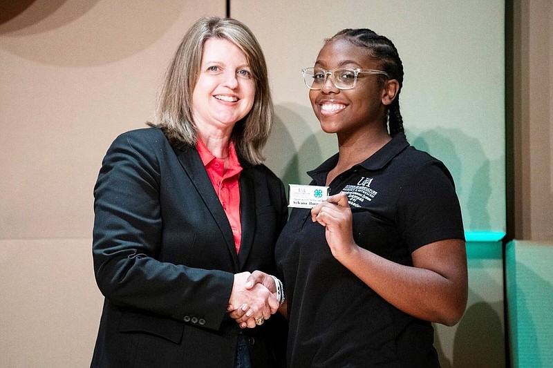 Angie Freel (left) associate department head for the Arkansas 4-H Program, presents the 4-H Ambassador nametag to Sylvana Burgess, a Jefferson County 4-H member, during a recent ceremony. 
(Special to The Commercial/Jefferson County Cooperative Extension Service)
