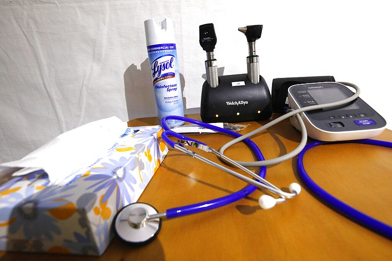 A can of disinfectant spray has a prominent place on the same table as stethoscopes and blood pressure monitors on a rolling table at a mobile health clinic in this April 8, 2020 file photo. (AP/Rogelio V. Solis)