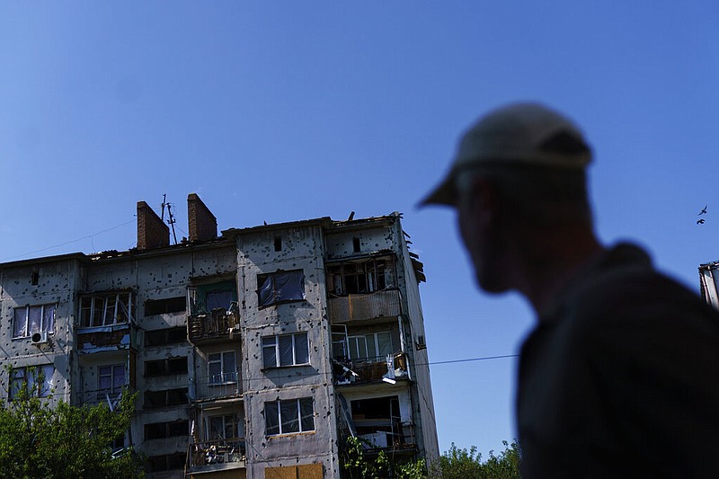 A pedestrian walks Saturday, Aug. 6, 2022, by a building damaged by a May rocket attack in Sloviansk, Donetsk region, eastern Ukraine. (AP/David Goldman)