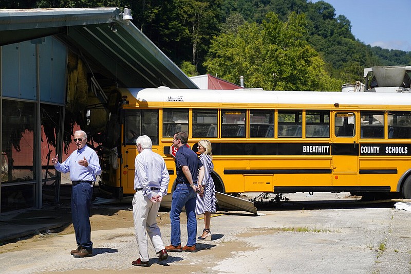 President Joe Biden, first lady Jill Biden, Kentucky Gov. Andy Beshear, second right, and Rep. Hal Rogers, R-Ky., third right, view flood damage, Monday, Aug. 8, 2022, in Lost Creek, Ky., where a bus floated into a building. (AP Photo/Evan Vucci)