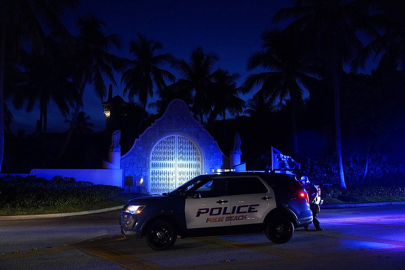 Police stand outside an entrance to former President Donald Trump's Mar-a-Lago estate, Monday, Aug. 8, 2022, in Palm Beach, Fla. Trump said in a lengthy statement that the FBI was conducting a search of his Mar-a-Lago estate and asserted that agents had broken open a safe. (AP Photo/Wilfredo Lee)