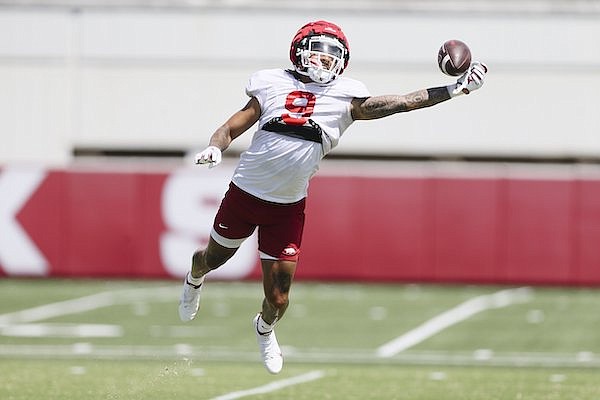 Arkansas receiver Jadon Haselwood attempts to catch a pass during practice Monday, Aug. 8, 2022, in Fayetteville.