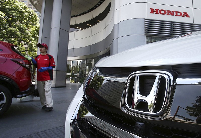 An employee of Honda Motor Co. cleans a Honda on display at company headquarters in Tokyo in this file photo. The global computer chip shortage, pandemic-related lockdowns in China and the rising costs of raw materials hurt the Japanese automaker’s first quarter profits.
(AP)