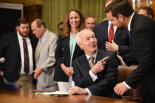 Gov. Asa Hutchinson celebrates with Sen. Jonathan Dismang and other Republican lawmakers before signing the two tax cut bills Thursday at the state Capitol. More photos at arkansasonline.com/812lege/.
(Arkansas Democrat-Gazette/Staci Vandagriff)