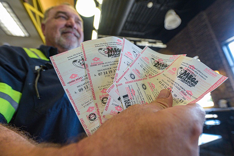 Frank Jackson of Fort Smith shows off several Mega Millions lottery tickets he purchased at OakCrest Market in downtown Fort Smith in this July 28, 2002 file photo. The jackpot for the Mega Millions lottery drawing on July 29 had surpassed $1 billion. (NWA Democrat-Gazette/Hank Layton)