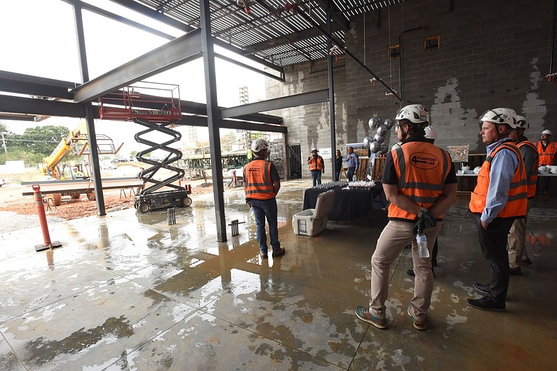 Construction workers, along with Bentonville school district officials and city officials, watch a beam being raised to bolt it into place during a topping-out ceremony at a new Bentonville elementary school at 5301 S.W. Barron Road in this Sept. 21, 2021 file photo. (NWA Democrat-Gazette/Flip Putthoff)