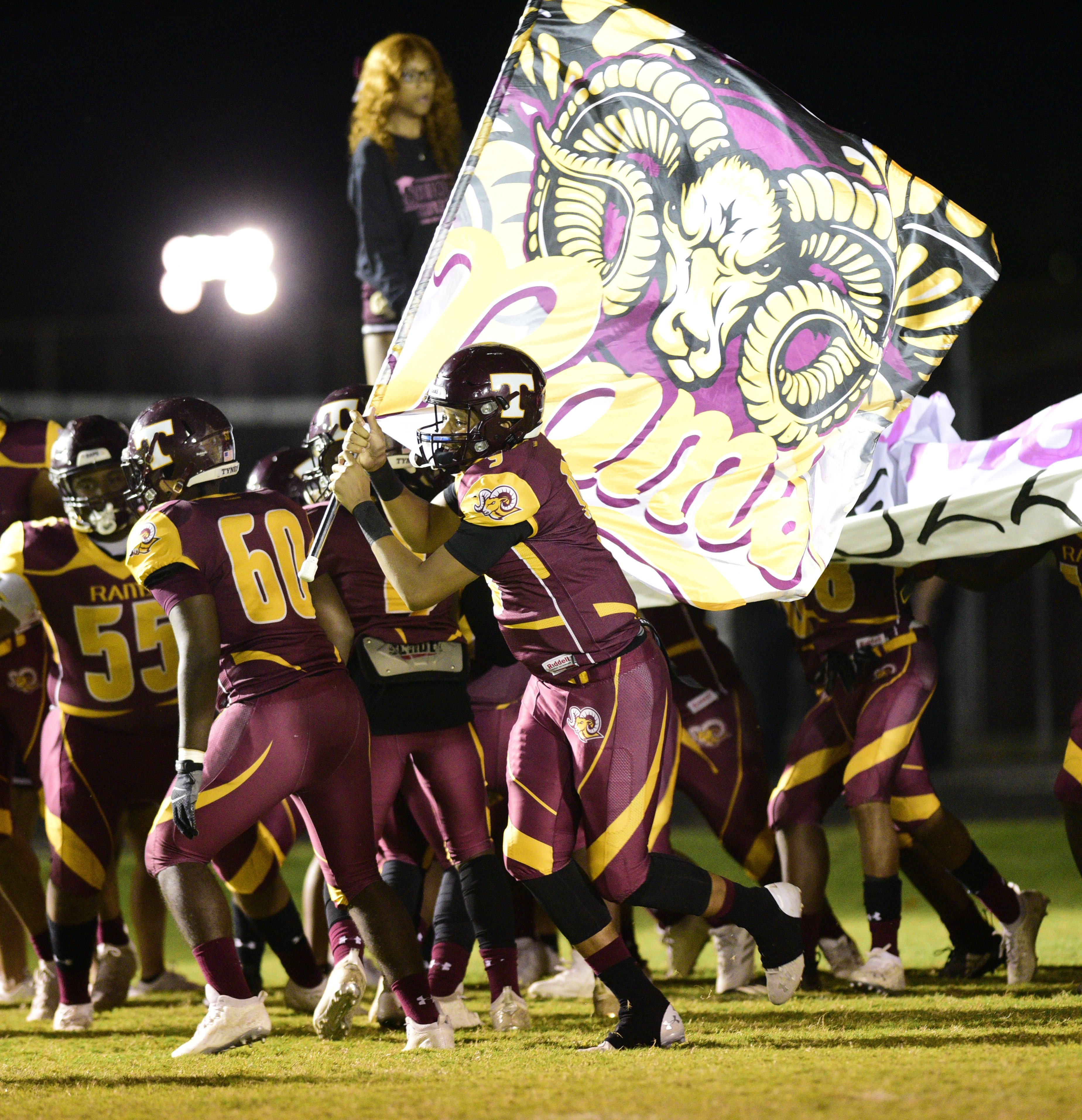 Staff Photo by Robin Rudd / Tyner quarterback Joshua Jackson (9) carries the Tyner flags as the Rams take the field. The Tyner Rams hosted the Bledsoe County Warriors in TSSAA football on October 1, 2021.