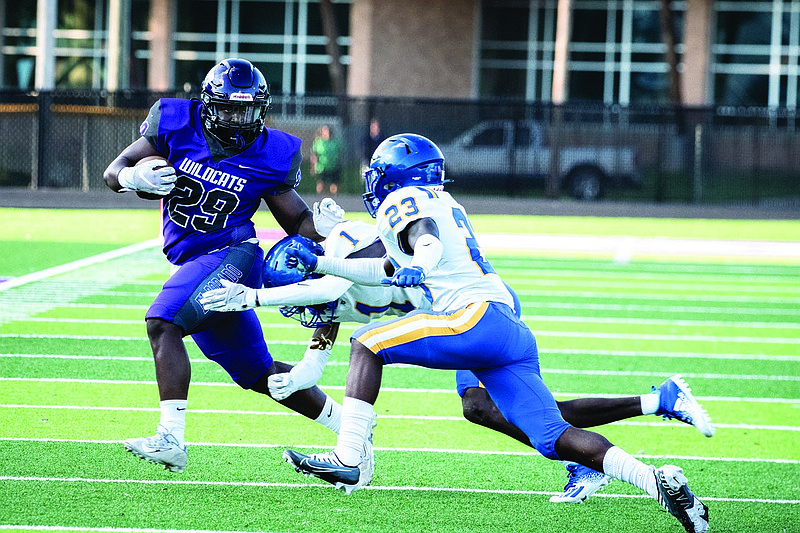 El Dorado's Rayvarius Joe picks up yards after a catch against North Little Rock. The Wildcats played the Charging Wildcats in a benefit game Friday at Memorial Stadium.