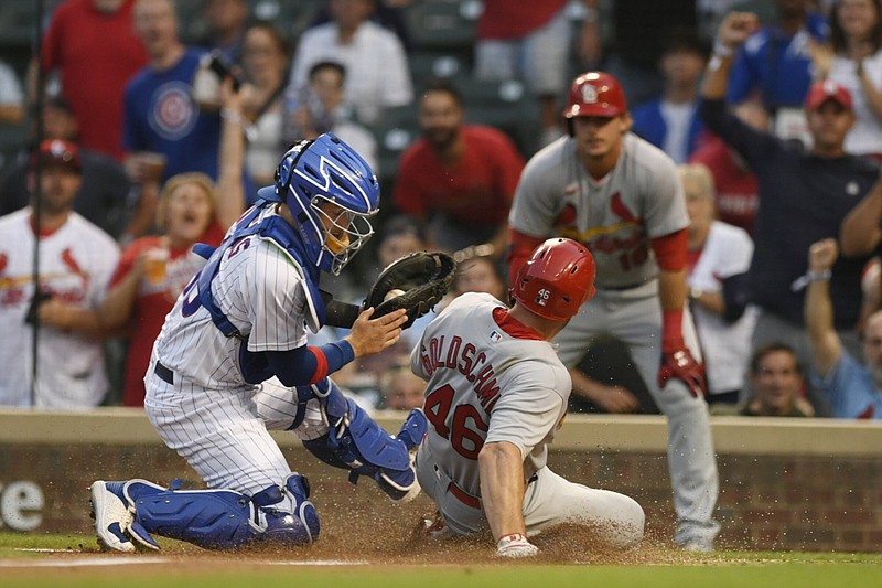 Chicago Cubs catcher P.J. Higgins (left) tags out St. Louis Cardinals first baseman Paul Goldschmidt at home plate Tuesday during the first inning of the Cardinals’ 13-3 victory over the Cubs in the second game of a doubleheader at Wrigley Field in Chicago. Teams will play 13 games against each division rival next season and will host all of the 29 other clubs at least once every two seasons as Major League Baseball switches to its first balanced schedule since 2000.
(AP/Paul Beaty)