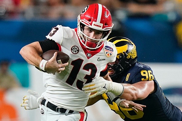 Georgia quarterback Stetson Bennett breaks away from Michigan defensive lineman Julius Welschof during the first half of the Orange Bowl NCAA College Football Playoff semifinal game, Friday, Dec. 31, 2021, in Miami Gardens, Fla. (AP Photo/Lynne Sladky)