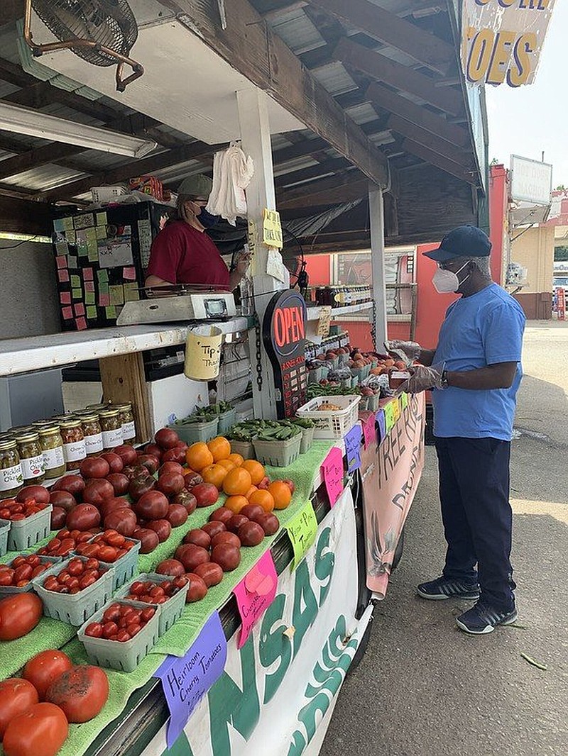 A customer buys fresh produce at Rick’s Farm Stand at Maumelle on Aug. 4, 2020. 
(Special to The Commercial/University of Arkansas System Division of Agriculture)