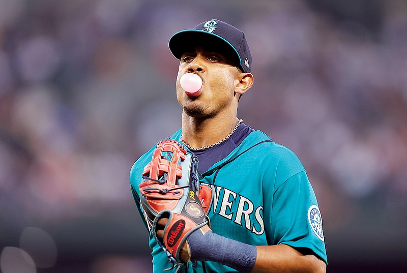 Julio Rodriguez of the Mariners blows a bubble as he runs to the dugout while leaving the field during the second inning of Friday’s game against the Guardians in Seattle. (Associated Press)