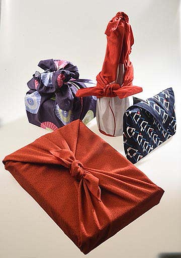 Staff photo by Tim Barber/ Various Japanese wrapped items for the holidays by wrapping with a square cloth: Furoshiki.