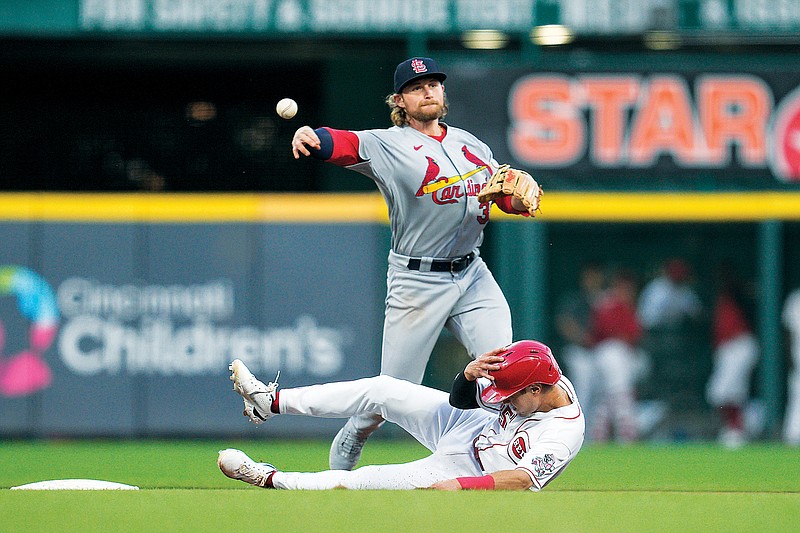 Cardinals second baseman Brendan Donovan throws to first base above a sliding Alejo Lopez of the Reds to complete a double play during the fourth inning of Tuesday night’s game in Cincinnati. (Associated Press)