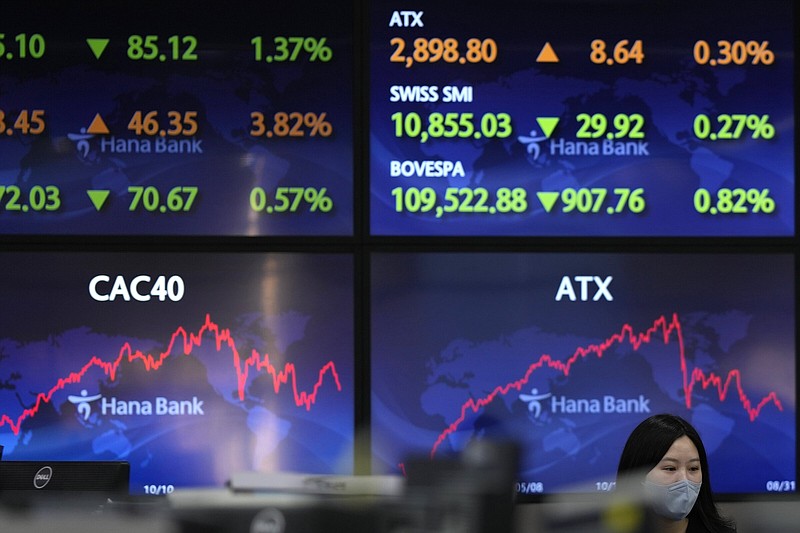 An employee of a bank walks by the screens at a foreign exchange trading room in Seoul, South Korea, on Thursday. Asian shares were mostly lower as investors braced for higher interest rates.
(AP/Lee Jin-man)