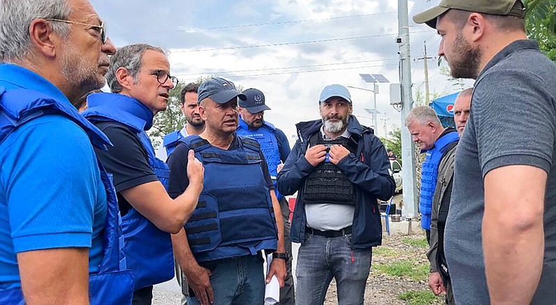 In this photo released by the International Atomic Energy Agency, the Director General of nuclear watchdog, Rafael Mariano Grossi, second from left, speaks to unidentified authorities as the UN agency mission heads to the Zaporizhzhia nuclear power plant, Zaporizhzhia, Ukraine, Thursday, Sept. 1, 2022. (International Atomic Energy Agency via AP)