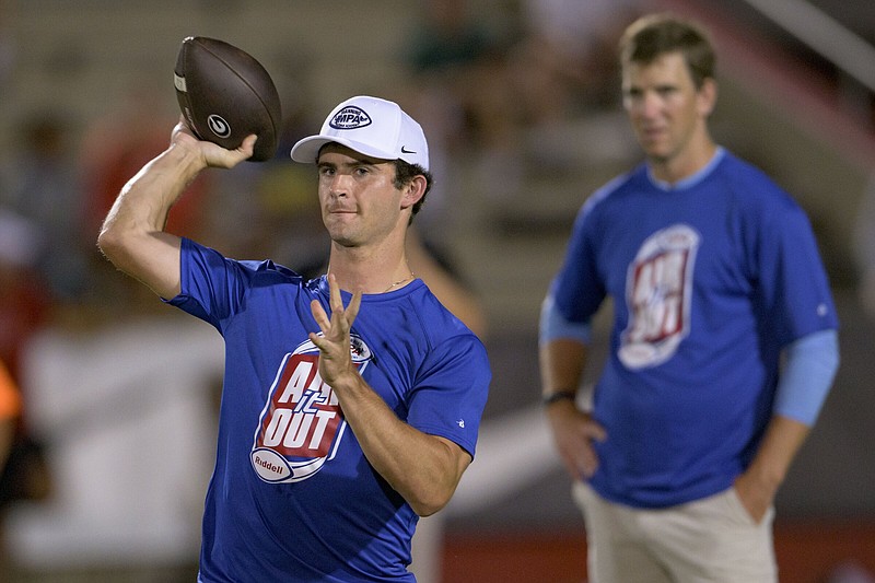 Georgia quarterback Stetson Bennett throws next to former NFL quarterback Eli Manning, right, at the Manning Passing Academy on the Nicholls State University campus in Thibodaux, La. Friday, June 24, 2022. (AP Photo/Matthew Hinton)