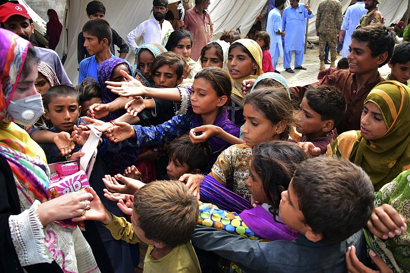 Children line up for relief Saturday, after heavy rain in Jaffarabad — a district of Pakistan’s southwestern Baluchistan province.
(AP/Arshad Butt)