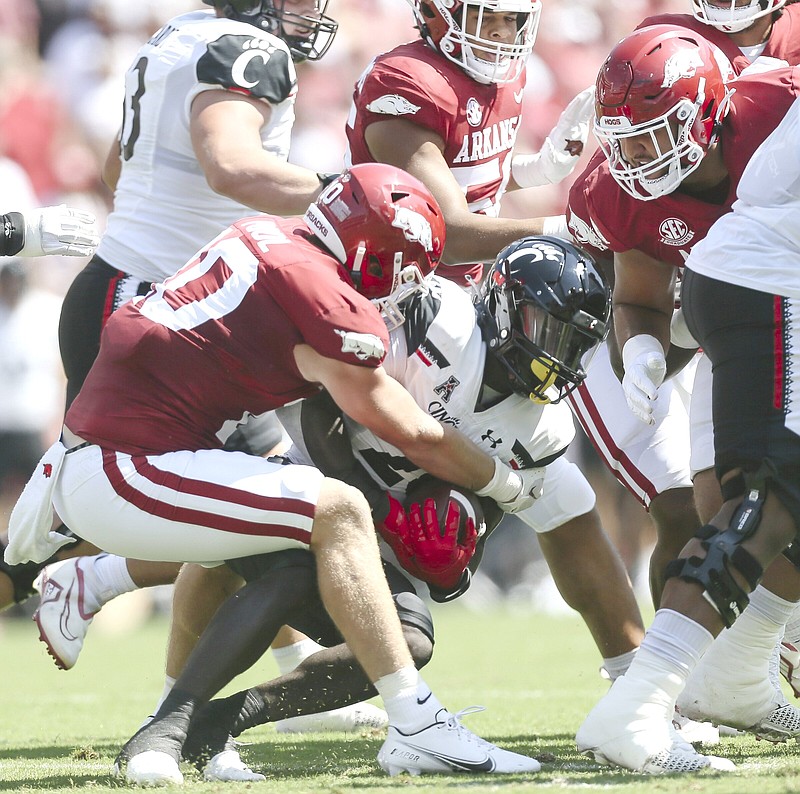 Arkansas linebacker Bumper Pool (10) tackles Cincinnati running back Myles Montgomery (26), Saturday, September 3, 2022 during the first quarter of a football game at Donald W. Reynolds Razorback Stadium in Fayetteville. Visit nwaonline.com/220904Daily/ for today's photo gallery...(NWA Democrat-Gazette/Charlie Kaijo)