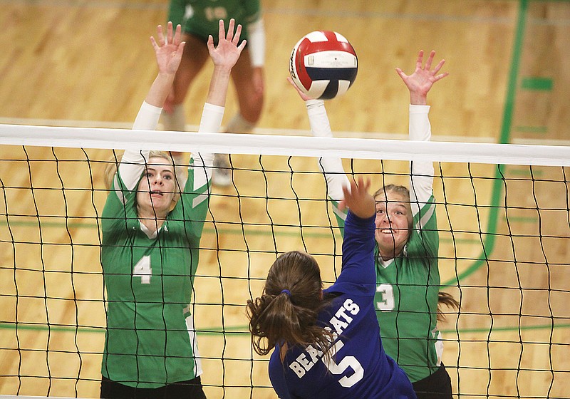 Blair Oaks middle hitter Anna Wekenborg (left) and outside hitter Aubrey Hardwick (right) reach up to block an attack from Hermann’s Holly Heldt during Tuesday night’s match in Wardsville. (Greg Jackson/News Tribune)