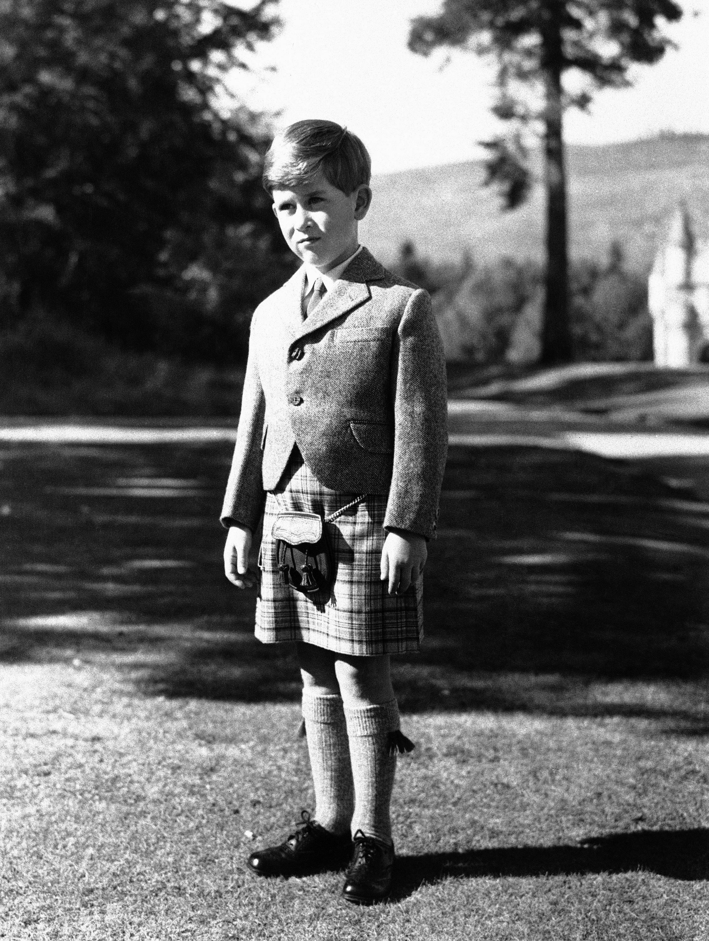 FILE - In this Nov. 12, 1955 file photo, Britain's Prince Charles poses for a photo, wearing a kilt of Balmoral Tartan on the grounds of Balmoral Castle, in Balmoral, Scotland. Prince Charles has been preparing for the crown his entire life. Now, that moment has finally arrived. Charles, the oldest person to ever assume the British throne, became king on Thursday Sept. 8, 2022, following the death of his mother, Queen Elizabeth II.  (AP Photo/File)