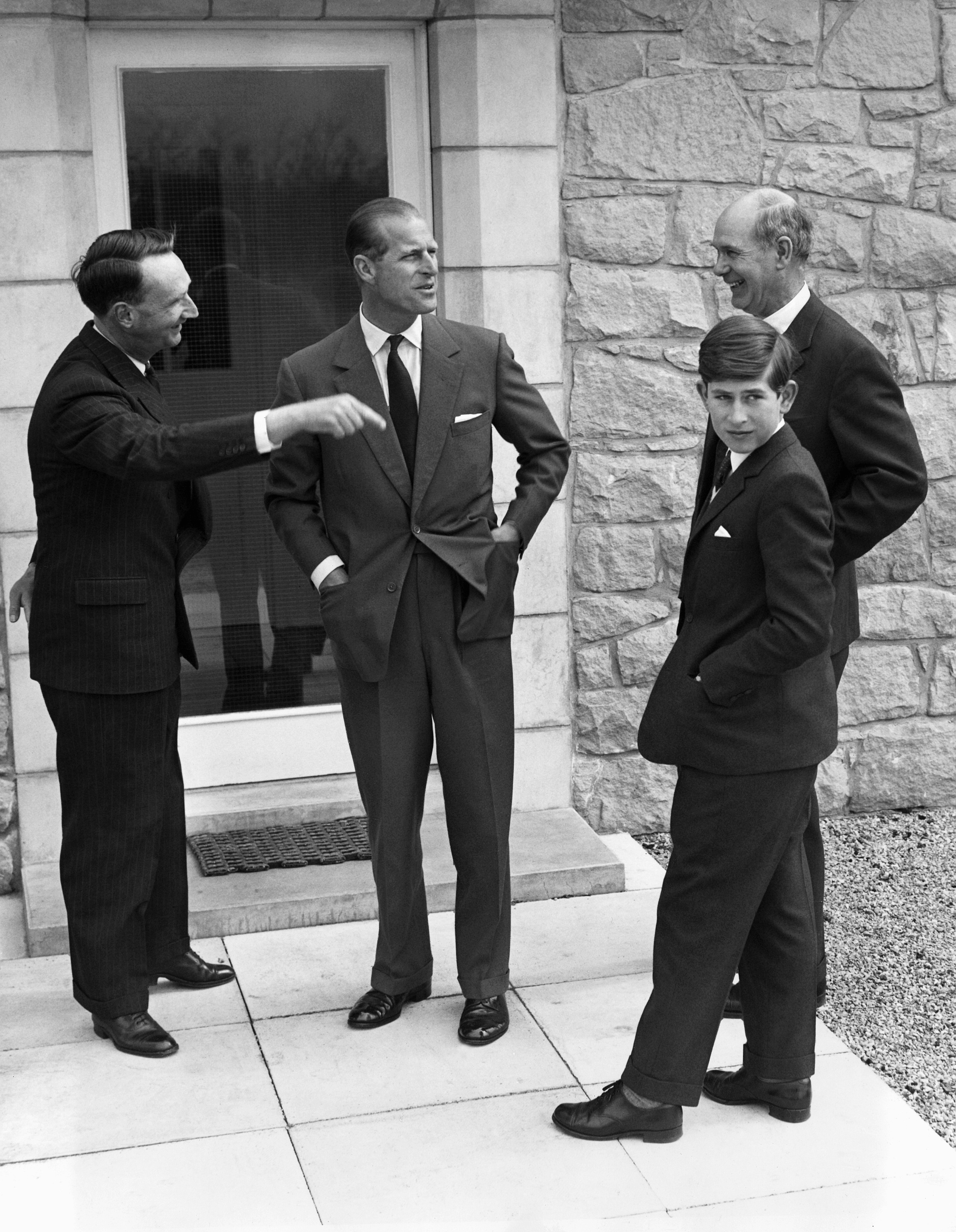 FILE - In this May 1, 1962 file photo, Britain's Prince Charles, tours his new school, Gordsonstoun, near Elgin, Scotland with his father, Prince Philip, as he arrives to start his first term. At left is house Master Robert Whitby, and Headmaster Mr. Robert Chew at right. Prince Charles has been preparing for the crown his entire life. Now, that moment has finally arrived. Charles, the oldest person to ever assume the British throne, became king on Thursday Sept. 8, 2022, following the death of his mother, Queen Elizabeth II.  (AP Photo/File)