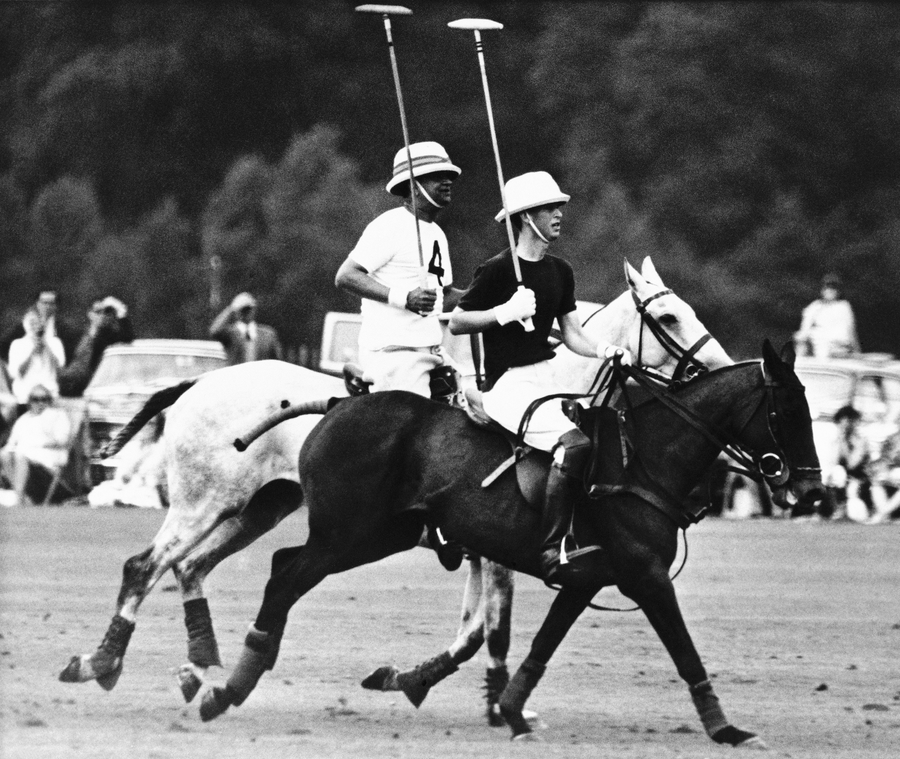 FILE - In this Aug. 8, 1965 file photo, Britain's Prince Charles is closely followed by a member of the opposing team as he plays polo for the Rangers team in the Chairman's Cup competition at Smith's Lawn, Great Windsor Park, in Windsor, England. Prince Charles has been preparing for the crown his entire life. Now, that moment has finally arrived. Charles, the oldest person to ever assume the British throne, became king on Thursday Sept. 8, 2022, following the death of his mother, Queen Elizabeth II. (AP Photo/File)
