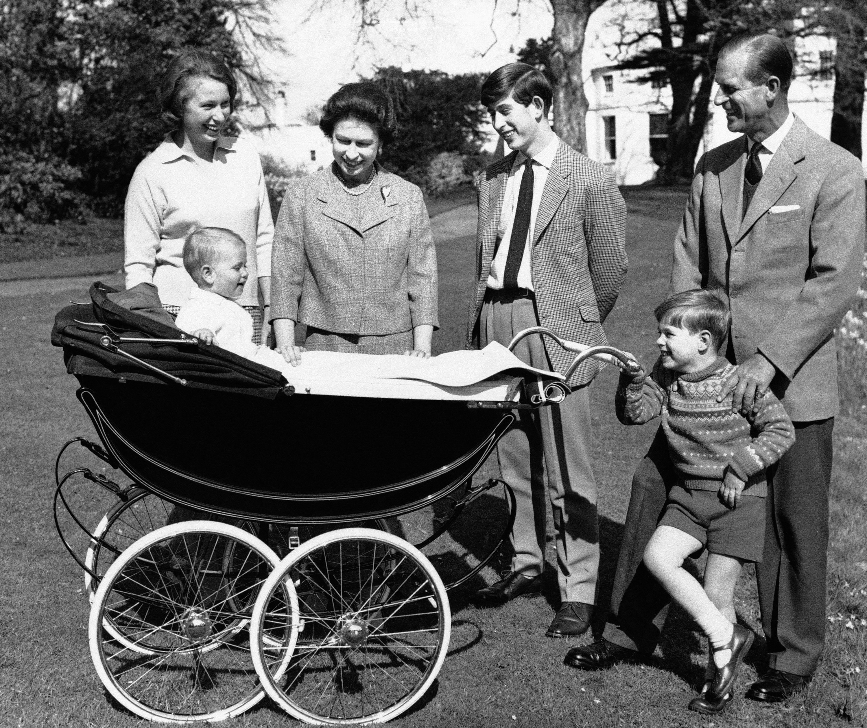 FILE - In this Dec. 19, 1965 file photo, Britain's Queen Elizabeth II and Prince Philip are surrounded by member of their family on the grounds of Windsor Castle, in Windsor, England. From left, Princess Anne, Prince Charles, Prince Andrew, 5. In the pram is Prince Edward. Prince Charles has been preparing for the crown his entire life. Now, that moment has finally arrived. Charles, the oldest person to ever assume the British throne, became king on Thursday Sept. 8, 2022, following the death of his mother, Queen Elizabeth II. (AP Photo/File)