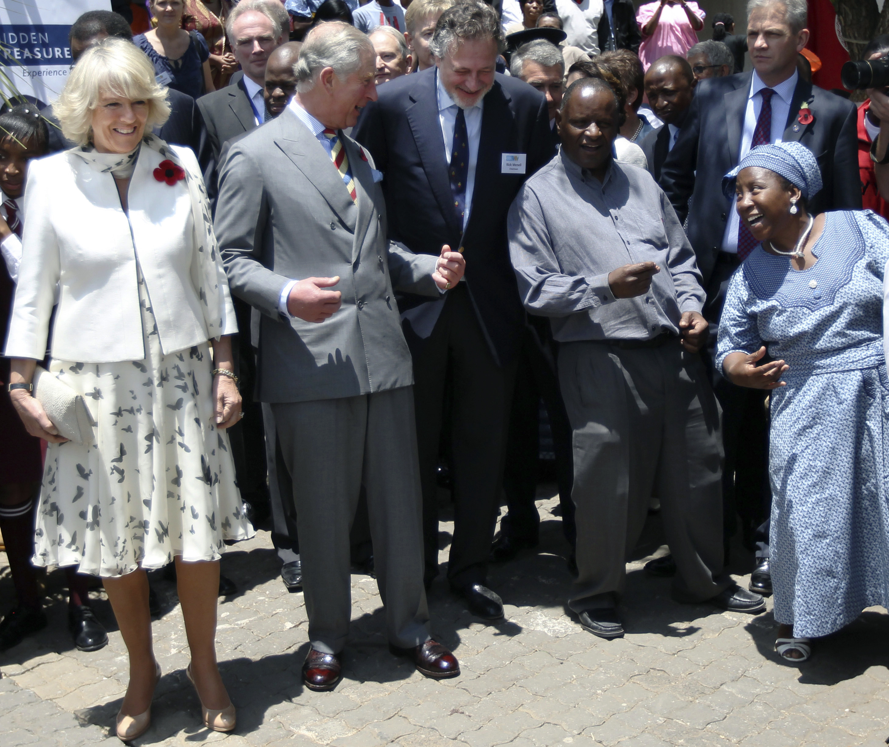 FILE - In this Thursday, Nov. 3, 2011 file photo, Britain's Prince Charles and his wife, Camilla, the Duchess of Cornwall, listen to a choir sing and dance during a tour of Soweto, South Africa. Prince Charles has been preparing for the crown his entire life. Now, that moment has finally arrived. Charles, the oldest person to ever assume the British throne, became king on Thursday Sept. 8, 2022, following the death of his mother, Queen Elizabeth II. (Kim Ludbrook, Pool Photo via AP, File)