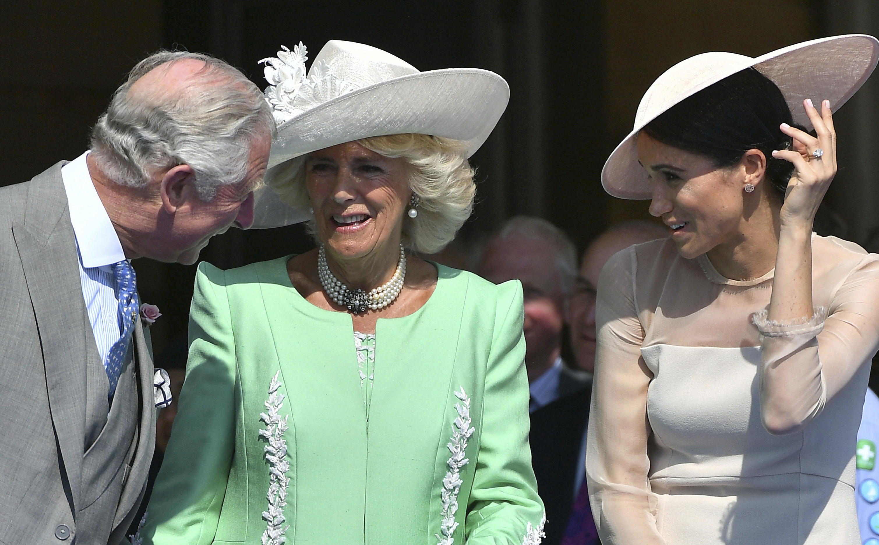 FILE - In this Tuesday, May 22, 2018 file photo, Britian's Prince Charles, left, speaks with Camilla, the Duchess of Cornwall and Meghan, the Duchess of Sussex, during a garden party at Buckingham Palace in London. Prince Charles has been preparing for the crown his entire life. Now, that moment has finally arrived. Charles, the oldest person to ever assume the British throne, became king on Thursday Sept. 8, 2022, following the death of his mother, Queen Elizabeth II. (Dominic Lipinski/Pool Photo via AP, File)