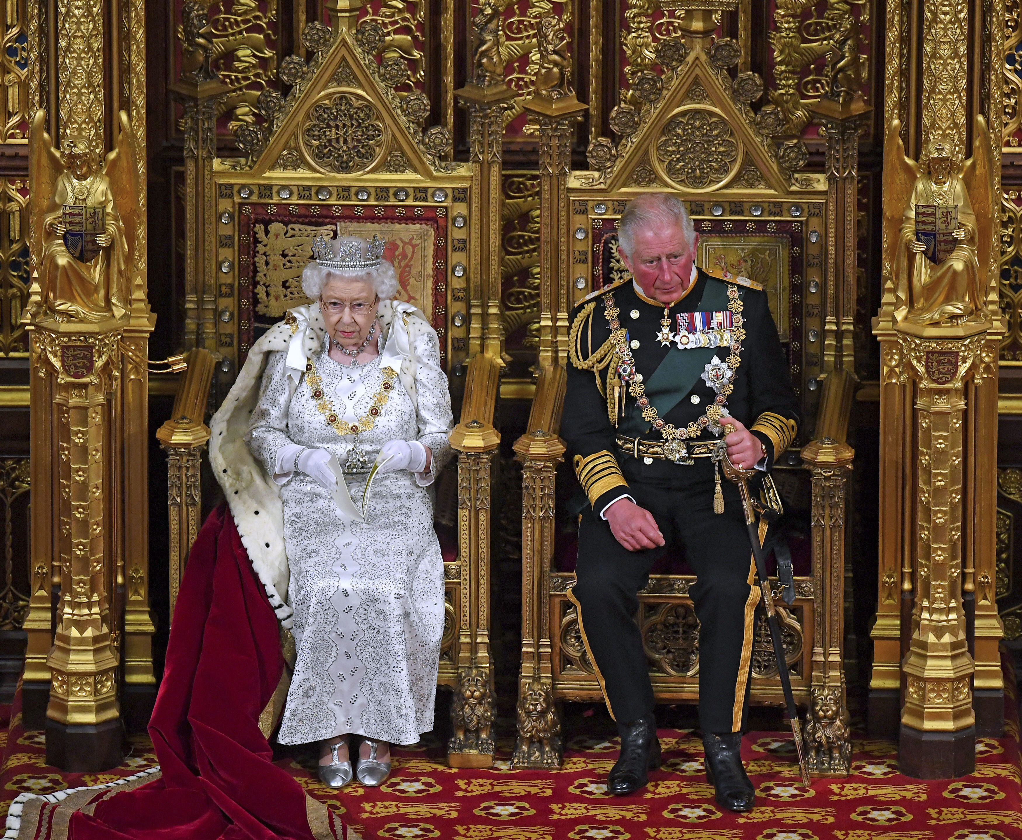 FILE - In this Oct. 14, 2019 file photo, Britain's Queen Elizabeth II, with Prince Charles, delivers the Queen's Speech at the official State Opening of Parliament in London. Prince Charles has been preparing for the crown his entire life. Now, that moment has finally arrived. Charles, the oldest person to ever assume the British throne, became king on Thursday Sept. 8, 2022, following the death of his mother, Queen Elizabeth II. (Victoria Jones/Pool via AP, File)