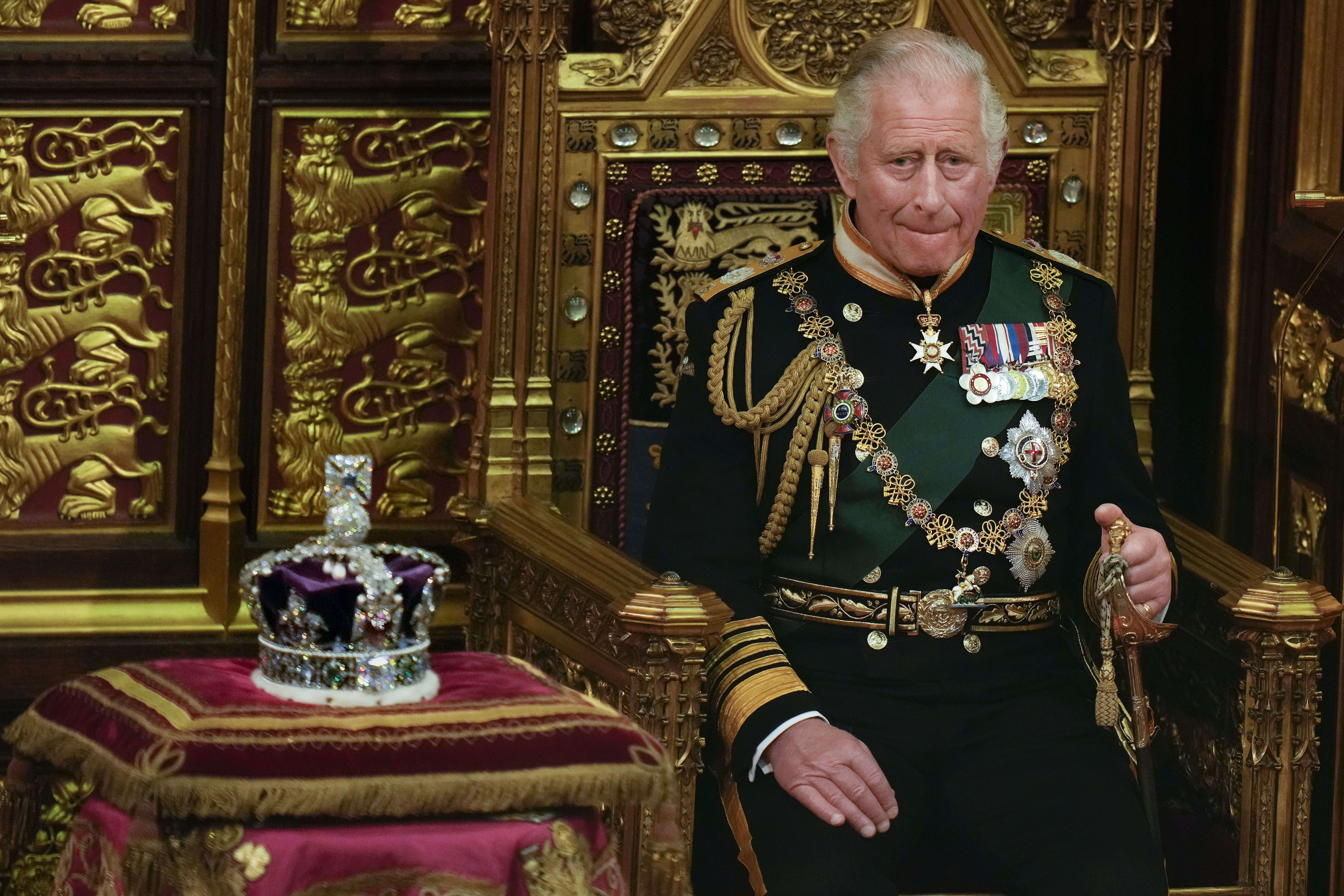 Prince Charles is seated next to the Queen's crown during the State Opening of Parliament, at the Palace of Westminster in London, May 10, 2022. Queen Elizabeth II did not attend the opening of Parliament amid ongoing mobility issues. (AP Photo/Alastair Grant, Pool, File)