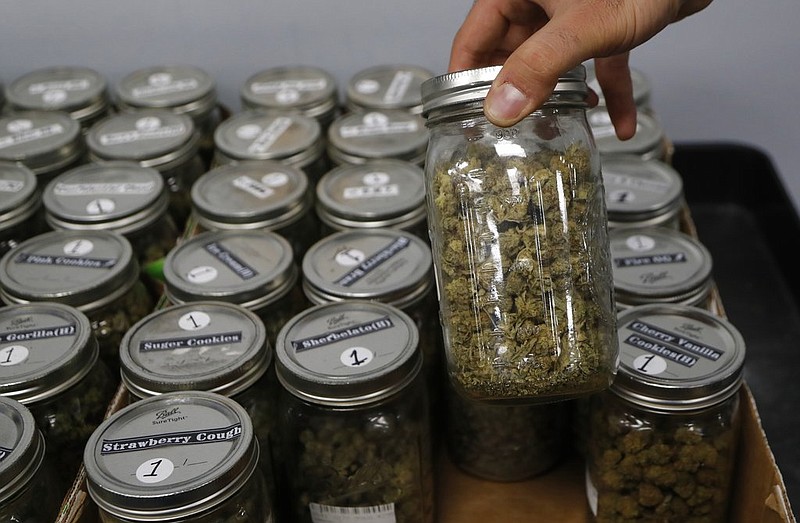 An attendant holds a mason jar of marijuana at the Far West Holistic Center dispensary in Detroit in this Nov. 7, 2018 file photo. (AP/Carlos Osorio)