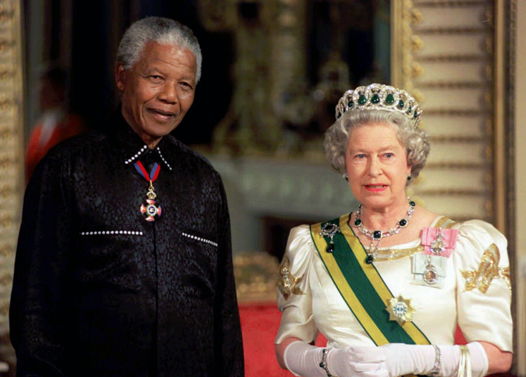 FILE - In this Tuesday, July 9, 1996 file photo, South African President Nelson Mandela stands with Britain Queen Elizabeth II on his arrival at Buckingham Palace, in London for a state banquet in his honour following his arrival in Britain. Queen Elizabeth II, Britain’s longest-reigning monarch and a rock of stability across much of a turbulent century, has died. She was 96. Buckingham Palace made the announcement in a statement on Thursday Sept. 8, 2022. (Pool Photo via AP)
