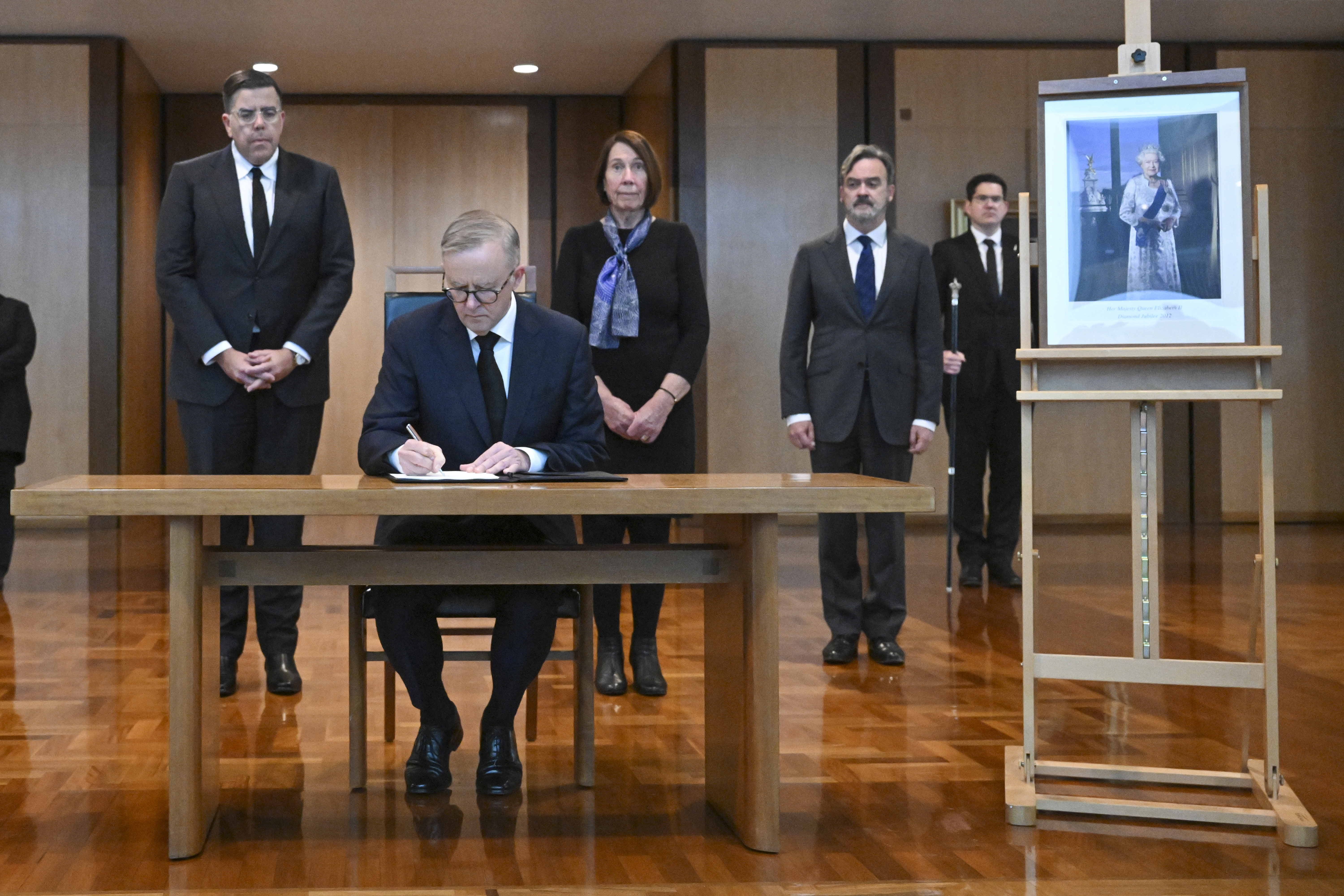 Australian Prime Minister Anthony Albanese signs the condolence book for the death of Queen Elizabeth II at Parliament House in Canberra, Australia, Friday, Sept. 9, 2022. Queen Elizabeth II, Britain's longest-reigning monarch and a rock of stability in a turbulent era for her country and the world, died Thursday, Sept. 8 after 70 years on the throne. She was 96. (Mick Tsikas via AP)