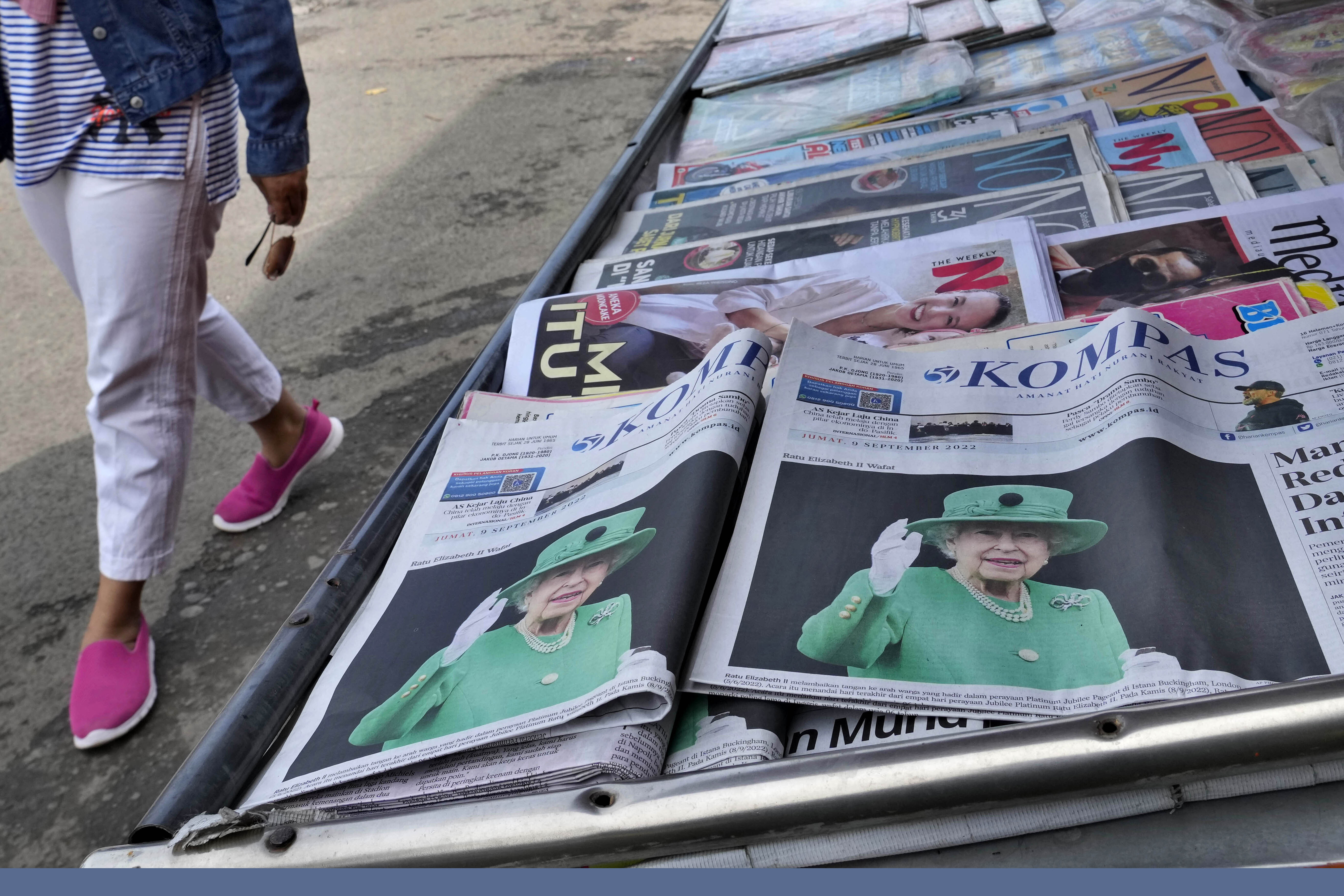 Newspapers fronting pictures of Queen Elizabeth II are displayed on a newsstand following her passing, in Jakarta, Indonesia, Friday, Sept. 9, 2022. Queen Elizabeth II, Britain's longest-reigning monarch, died Thursday after 70 years on the throne. She was 96. (AP Photo/Tatan Syuflana)