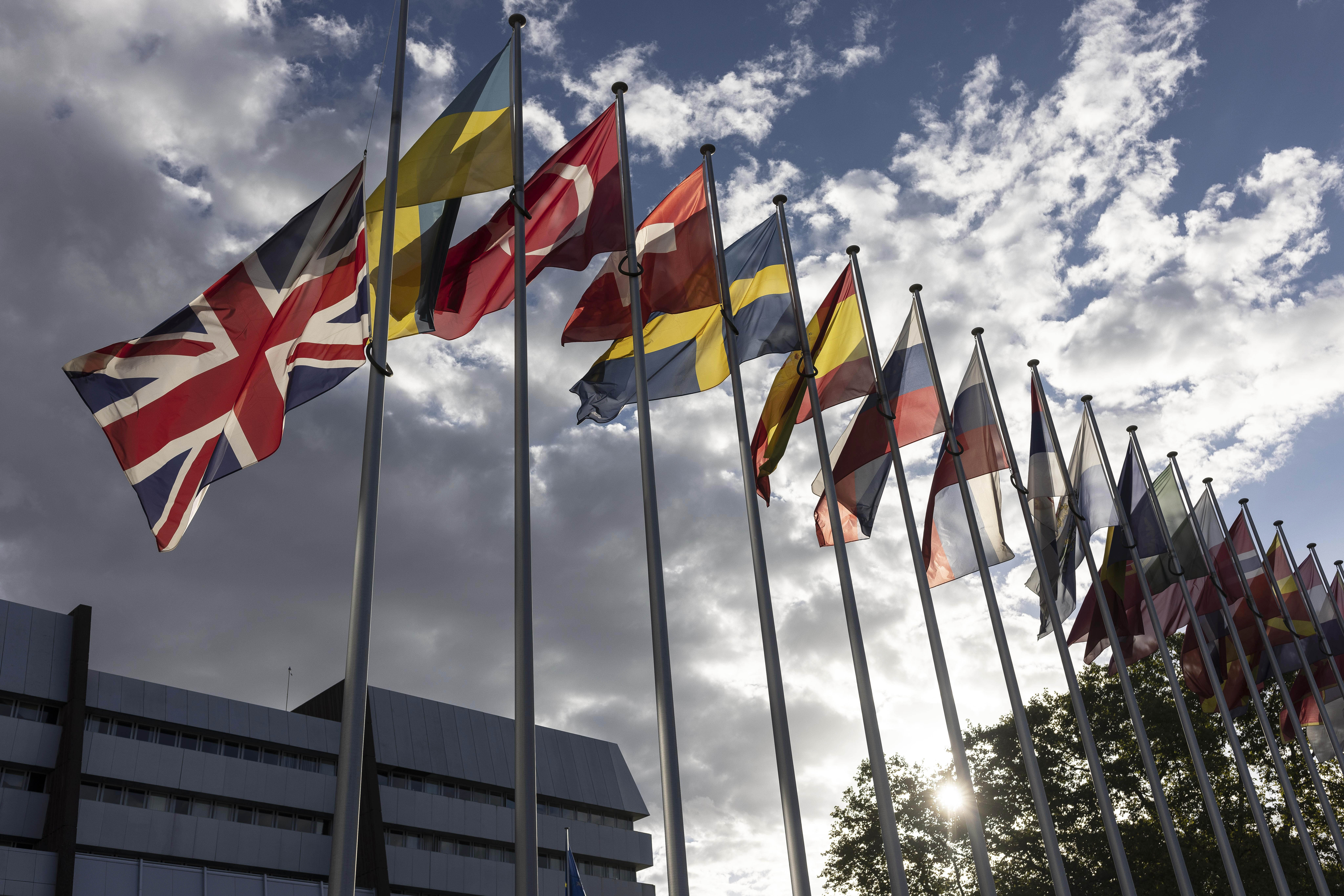 The British flag, left, flies at half mast in front of the Council of Europe, following Britain's Queen Elizabeth II's death on Thursday at the age of 96, in Strasbourg, eastern France, Friday, Sept. 9, 2022. (AP Photo/Jean-Francois Badias)