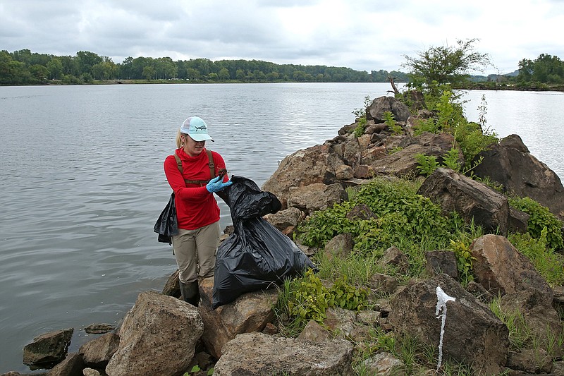 Brie Olsen cleans up trash on a jetty along the banks of the Arkansas River in Murray Park as part of the Arkansas Cleanup on Saturday. More photos at arkansasonline.com/911cleanup/.
(Arkansas Democrat-Gazette/Colin Murphey)