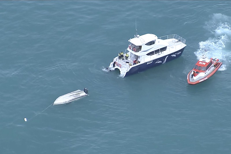 Two rescue boats close in on a capsized boat Saturday near Kaikoura, New Zealand. Five people died after the small charter boat capsized, authorities say, in what may have been a collision with a whale. Another six people aboard the boat were rescued.
(AP/TVNZ)