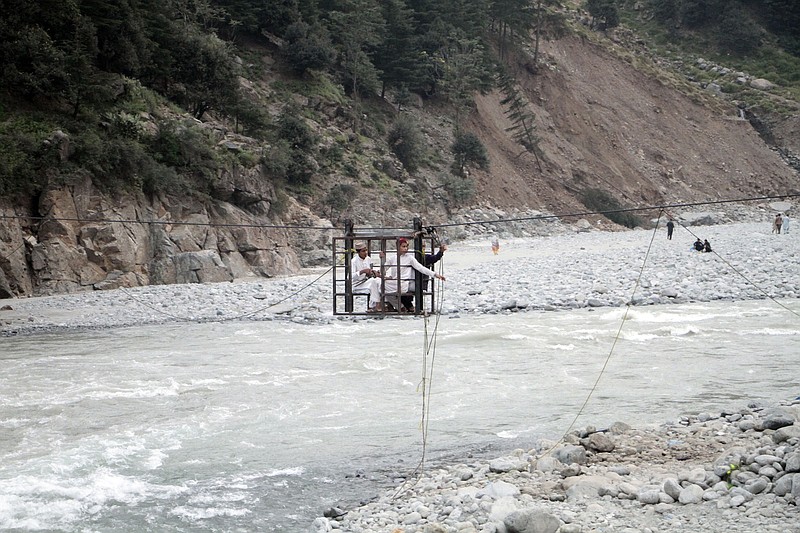 People cross a river on a suspended cradle Friday in Kalam Valley in northern Pakistan.
(AP/Naveed Ali)