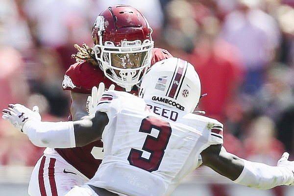 Arkansas receiver Jadon Haselwood (9) stiff arms a South Carolina defender during a game Saturday, Sept. 10, 2022, in Fayetteville.