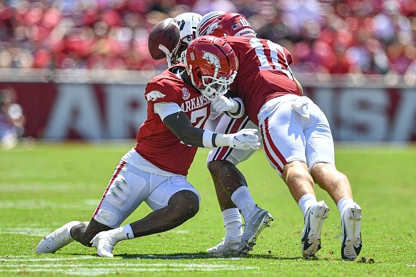Arkansas defensive back Latavious Brini (7) tackles and forces South Carolina running back MarShawn Lloyd (1) to fumble on Saturday, Sept. 10, 2022, during the fourth quarter of the Razorbacks’ 44-30 win at Donald W. Reynolds Razorback Stadium in Fayetteville.
