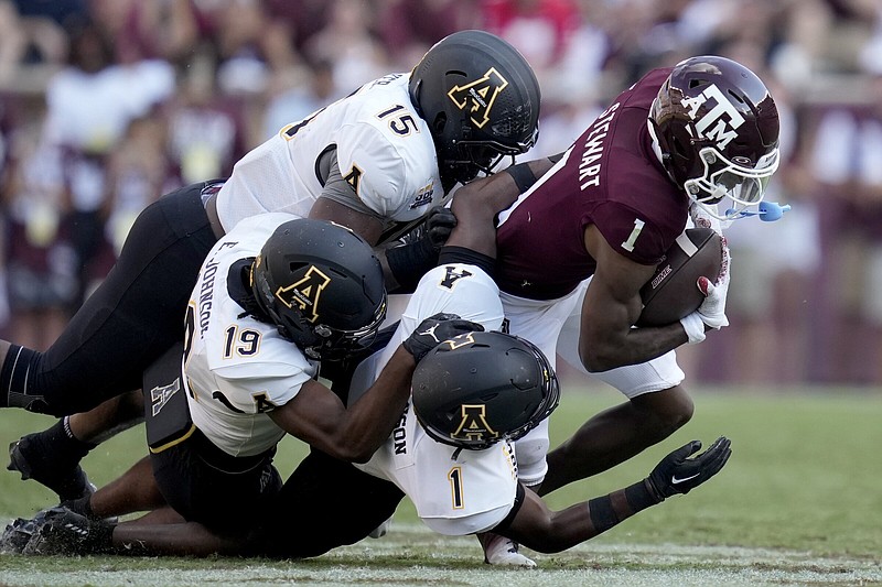 Texas A&M wide receiver Evan Stewart (1) is stopped after a catch by Appalachian State linebacker Andrew Parker (15), Ethan Johnson (19) and Kaleb Dawson (1) during the second half of an NCAA college football game Saturday, Sept. 10, 2022, in College Station, Texas. (AP Photo/Sam Craft)