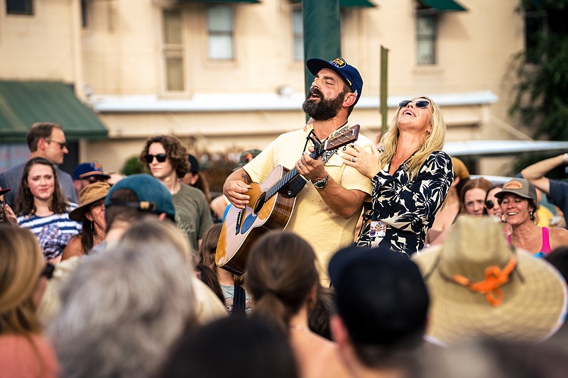 Contributed Photo by Roger Ho / Drew and Ellie Holcomb entertain fans waiting to get back into the Moon River Festival during a rain delay Sunday.