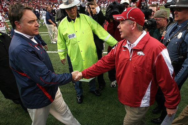 Arkansas coach Bobby Petrino (right) and Ole Miss coach Houston Nutt shake hands following the Razorbacks' 38-24 victory over the Rebels on Saturday, Oct. 23, 2010, in Fayetteville.