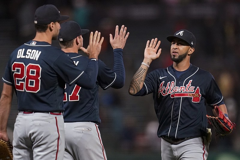 Atlanta Braves' Matt Olson, Austin Riley and Eddie Rosario, from left, celebrate after the team's 5-1 victory against the San Francisco Giants in a baseball game in San Francisco, Tuesday, Sept. 13, 2022. (AP Photo/Godofredo A. Vásquez)